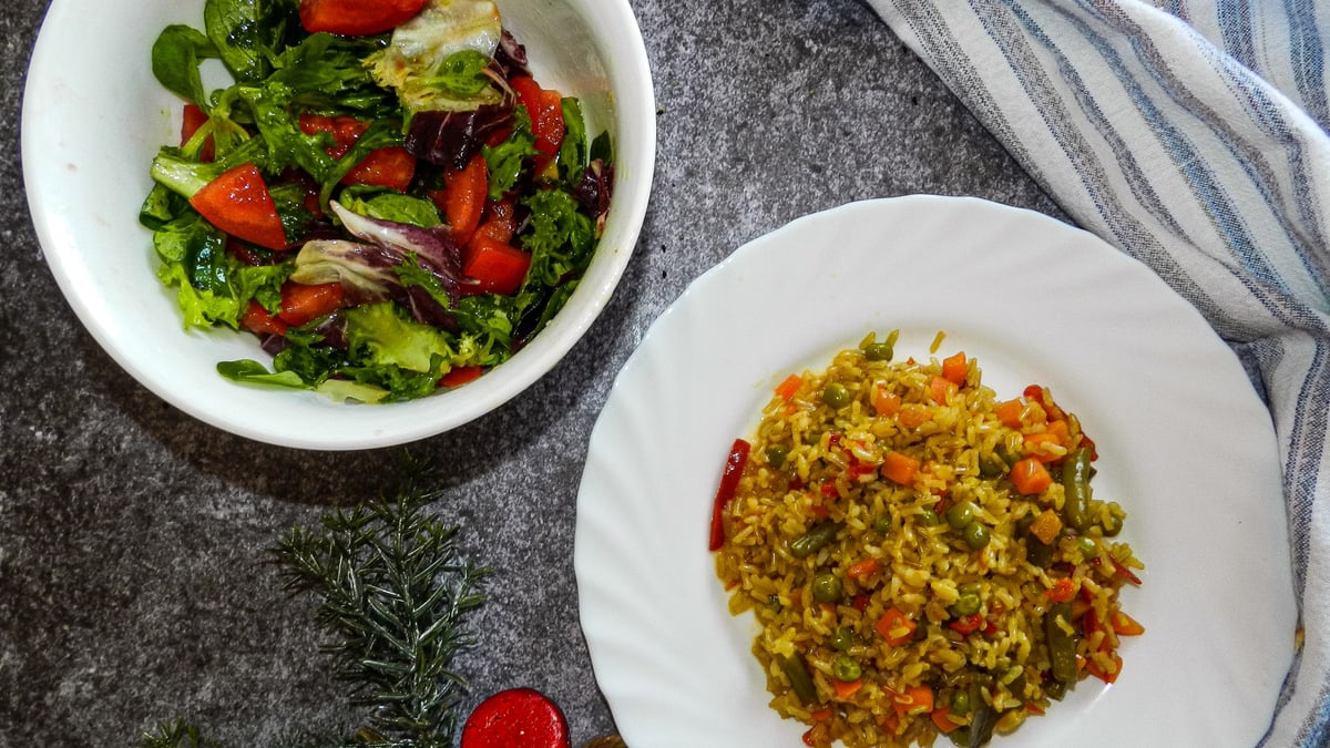 Vibrant healthy salad and vegetable rice on a table, perfect for a nutritious meal.
